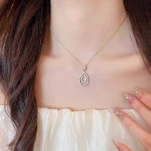 Sparkling gold waterdrop pendant necklace with cubic zirconia stones worn by an elegant model