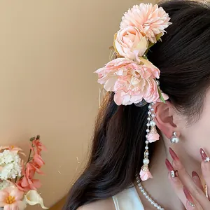 Gros plan d'une pince à cheveux à fleurs roses avec d'élégants glands de perles.