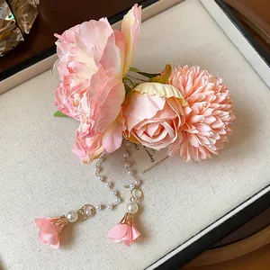 Vue détaillée de la pince à cheveux avec fleurs en tissu rose et pampilles de perles
