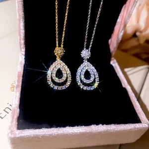 Macro view of two sparkling zircon water-drop pendants in elegant gold and silver finishes