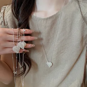 Elegant silver beaded heart pendant necklace shown on a beige knit top for a chic look.