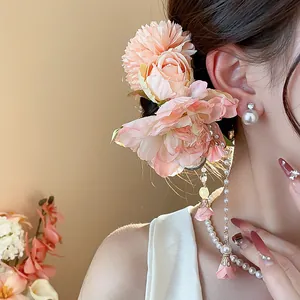 Gros plan d'une pince à cheveux fleur rose avec d'élégants pendentifs à pampilles