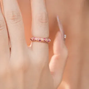 Detailed view of a rose gold ring pave-set with pink and white cubic zirconia stones.