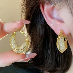 Detailed close-up showing the intricate golden glass mesh texture of these hoop earrings