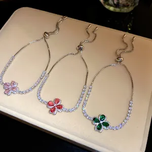 Detail showing three adjustable zircon clover bracelets in pink, red, and green colors