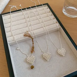 Close-up of minimalist beaded heart pendant necklaces displayed in a luxury jewelry box