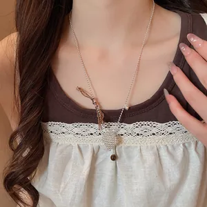 Detailed view of a minimalist heart flower pendant necklace on a model's neck.
