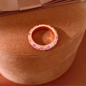 Close-up of a rose gold ring paved with shimmering pink and white cubic zirconia stones.