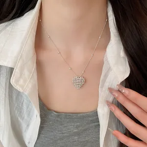 Minimalist silver beaded heart pendant necklace worn on a model with white shirt