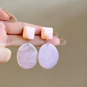 Orecchini pendenti geometrici in resina con motivo marmoreo lavanda e perni rosa.