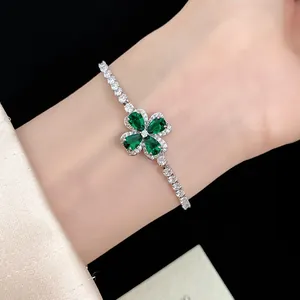 Close-up of a silver-toned clover bracelet featuring green pear-cut zirconia petals