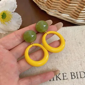 Chic dopamine style resin hoop earrings featuring a green ball and bold yellow ring dangle