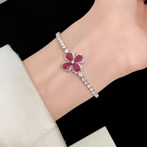 Elegant silver bracelet featuring a four-leaf lucky clover charm with red and white zircons