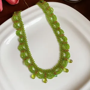 Vue détaillée du collier en dentelle de perles de verre vertes fait main avec breloques