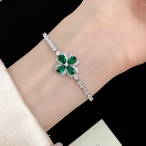 Detailed view of elegant silver clover bracelet with sparkling green zircon stones