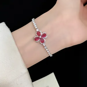 Detailed view of a silver-tone clover bracelet with sparkling red and clear crystals