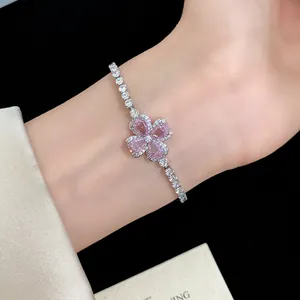 Detailed view of a shiny silver bracelet with a pink zircon lucky clover flower