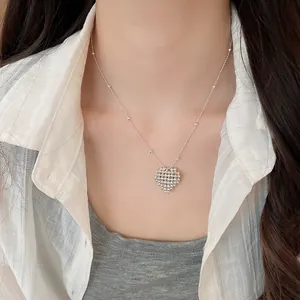 Detailed view of minimalist silver heart pendant necklace on a model for daily wear.