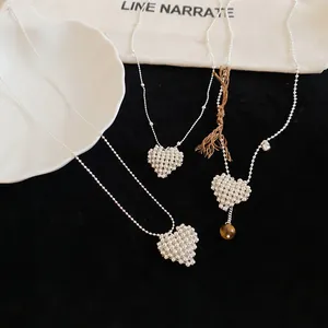 Exquisite detail view of silver heart beaded necklaces on a black velvet background