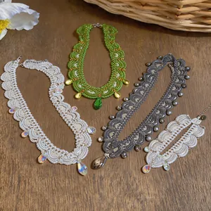 Détail d'un ensemble de collier et bracelet en perles avec pendentifs en forme de goutte.