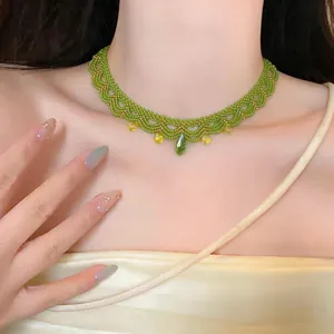 Gros plan d'un élégant collier ras de cou en perles vertes avec des pendentifs