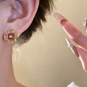 Close-up detail of a vintage style gradient flower stud earring worn on model ear.