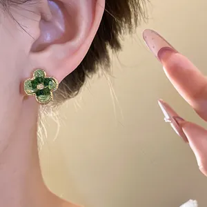 Close-up detail of vintage Korean style green gradient crystal flower stud earrings on ear