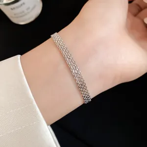 Detailed view of an elegant silver multi-layer mesh chain bracelet worn on a wrist