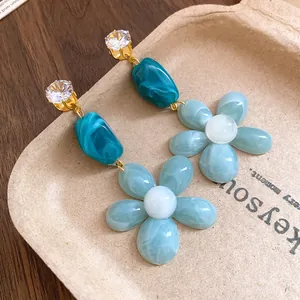 Close-up detail of stylish zircon resin flower drop earrings for a fresh summer look