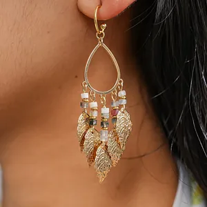 Detailed shot of gold-tone bohemian teardrop earrings with elegant metallic leaf tassels