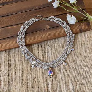 Détail d'un collier en perles d'acier inoxydable avec de grandes gouttes de cristal irisé
