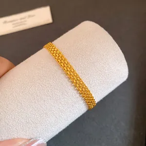 Macro detail showing the intricate multi-layer gold-colored mesh chain bracelet design