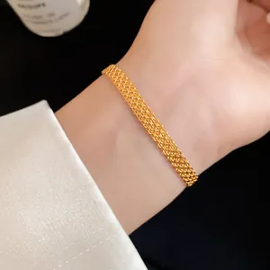 Close-up of an elegant gold-toned woven chain bracelet worn on a woman's wrist for detail view.