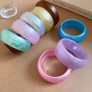 Gros plan sur de larges bracelets en résine irisée aux couleurs gelées estivales fraîches