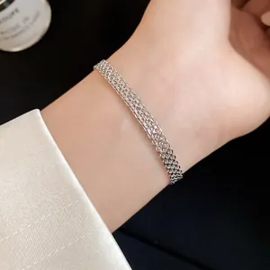 Close-up of elegant silver mesh chain bracelet with intricate interwoven design on wrist