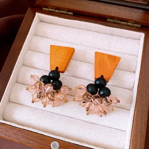 Detailed macro view of vintage ethnic earrings featuring orange wood and pink glass beads