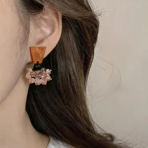 Detailed shot of vintage ethnic style earrings with wooden top and pink glass beads