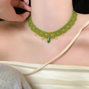 Détail d'un élégant ras-de-cou en perles vertes avec un pendentif en cristal vert éclatant