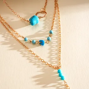 Detail shot of retro multi-layered necklace with turquoise stones and gold chain