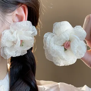 Detailed macro view of cream chiffon flower stud earrings featuring pink rose embroidery