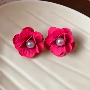 Detailed view of elegant magenta flower stud earrings featuring a glossy pearl center