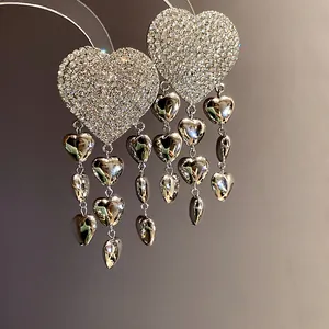 Detailed close-up of sparkling heart tassel earrings with silver-tone rhinestones
