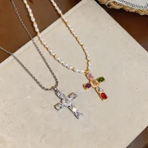 Detail view of two cross necklaces with pearls, zircons, and colorful gemstones in luxury style.