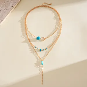 Detail view of a vintage multi-layer gold necklace with turquoise stones and beads