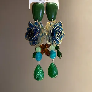 Detailed view of vintage resin flower earrings with emerald green waterdrop pendants