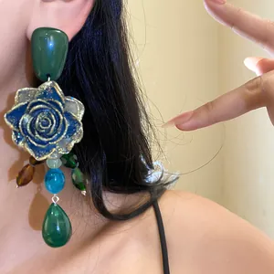Close-up of vintage resin flower earrings with colorful crystal water drop pendants.