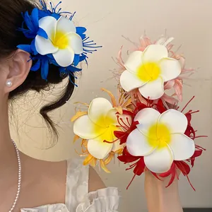 Dettaglio di un gruppo di colorate forcine per capelli a forma di fiore di frangipane