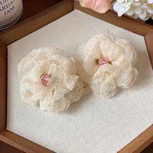 Close-up detail of delicate layered chiffon flower earrings with pink rose center.