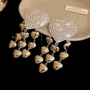 Detailed close-up of sparkly rhinestone heart earrings with elegant cascading tassels