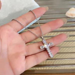 Close-up detail of silver-toned cross pendant necklace with sparkling cubic zirconia